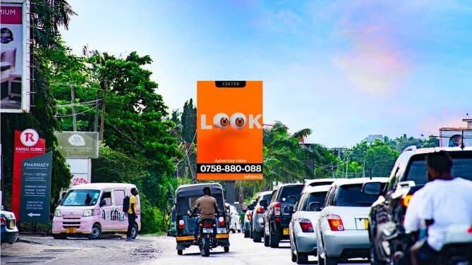 An Ashton digital billboard with a “LOOK” creative above traffic in Dar es Salaam