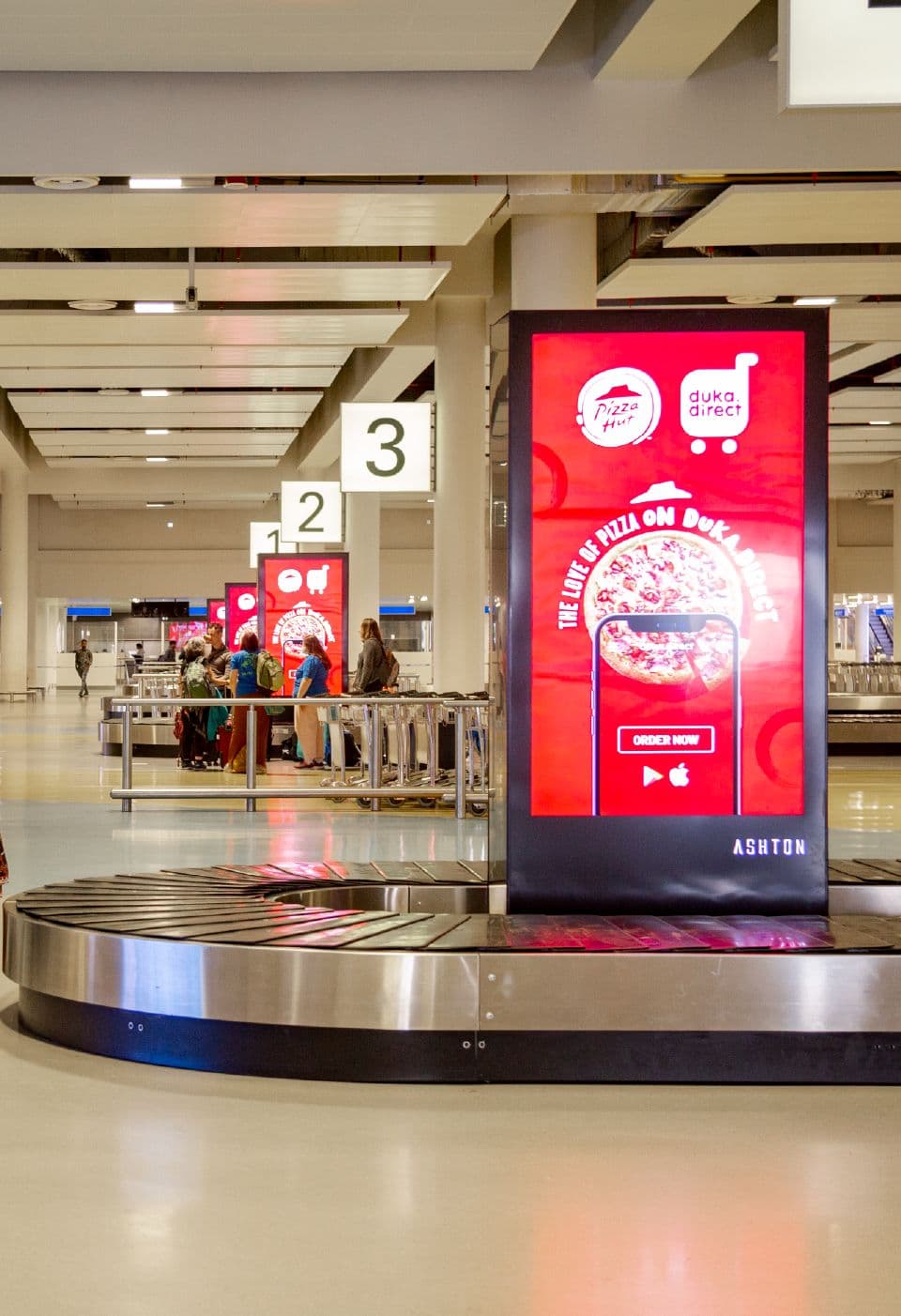 A digital totem screen in the airport baggage hall