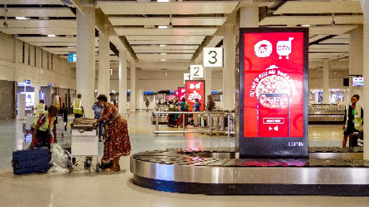 A digital totem in the airport baggage hall